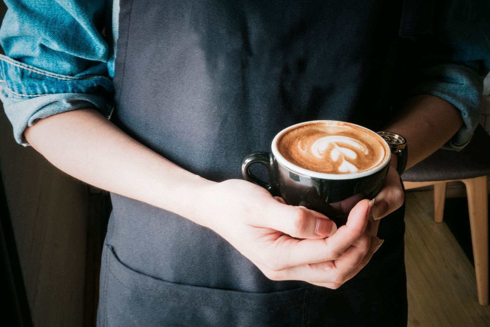 Barista presenting a cup of coffee with latte art