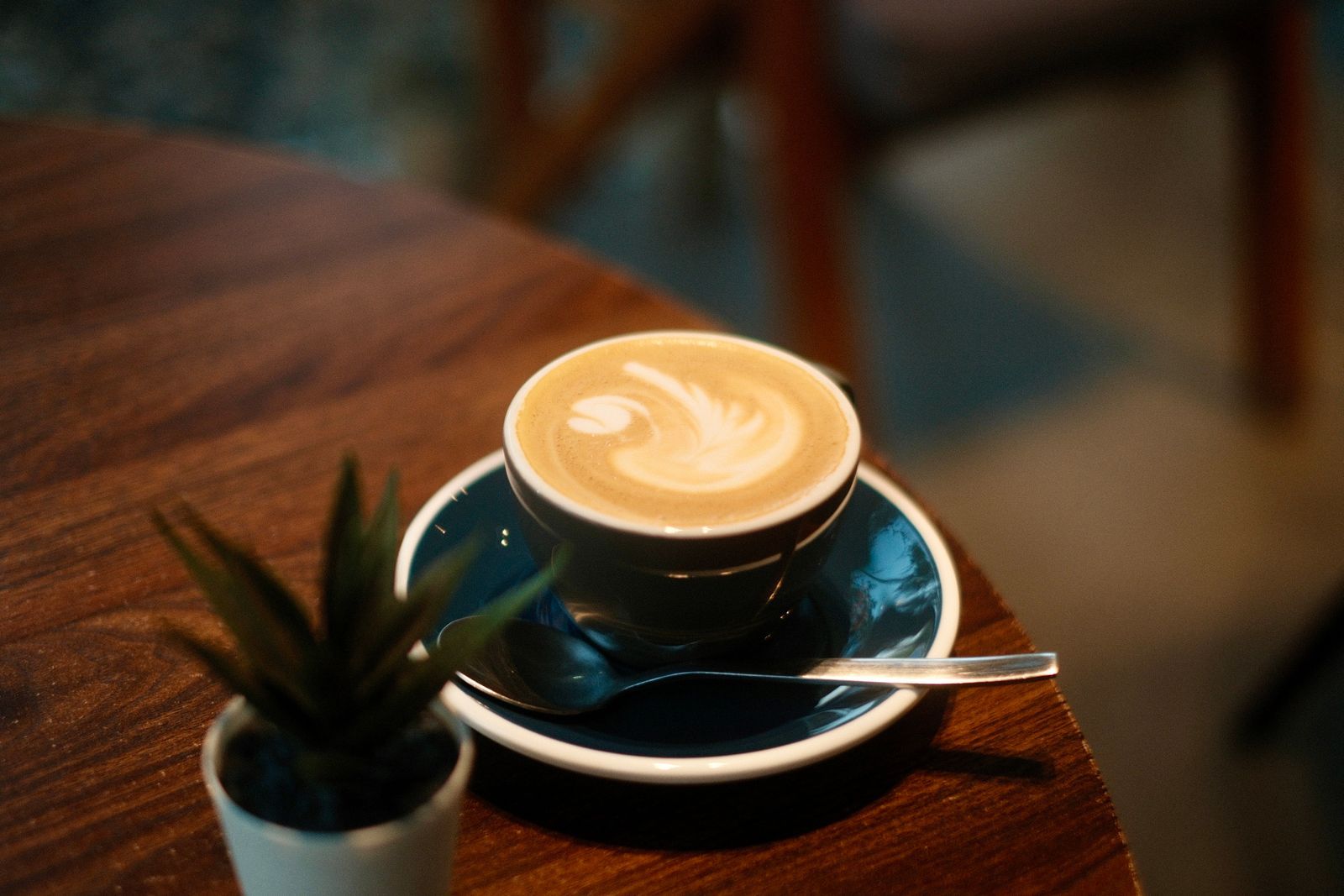 Warm latte with foam art on a table in a cozy café