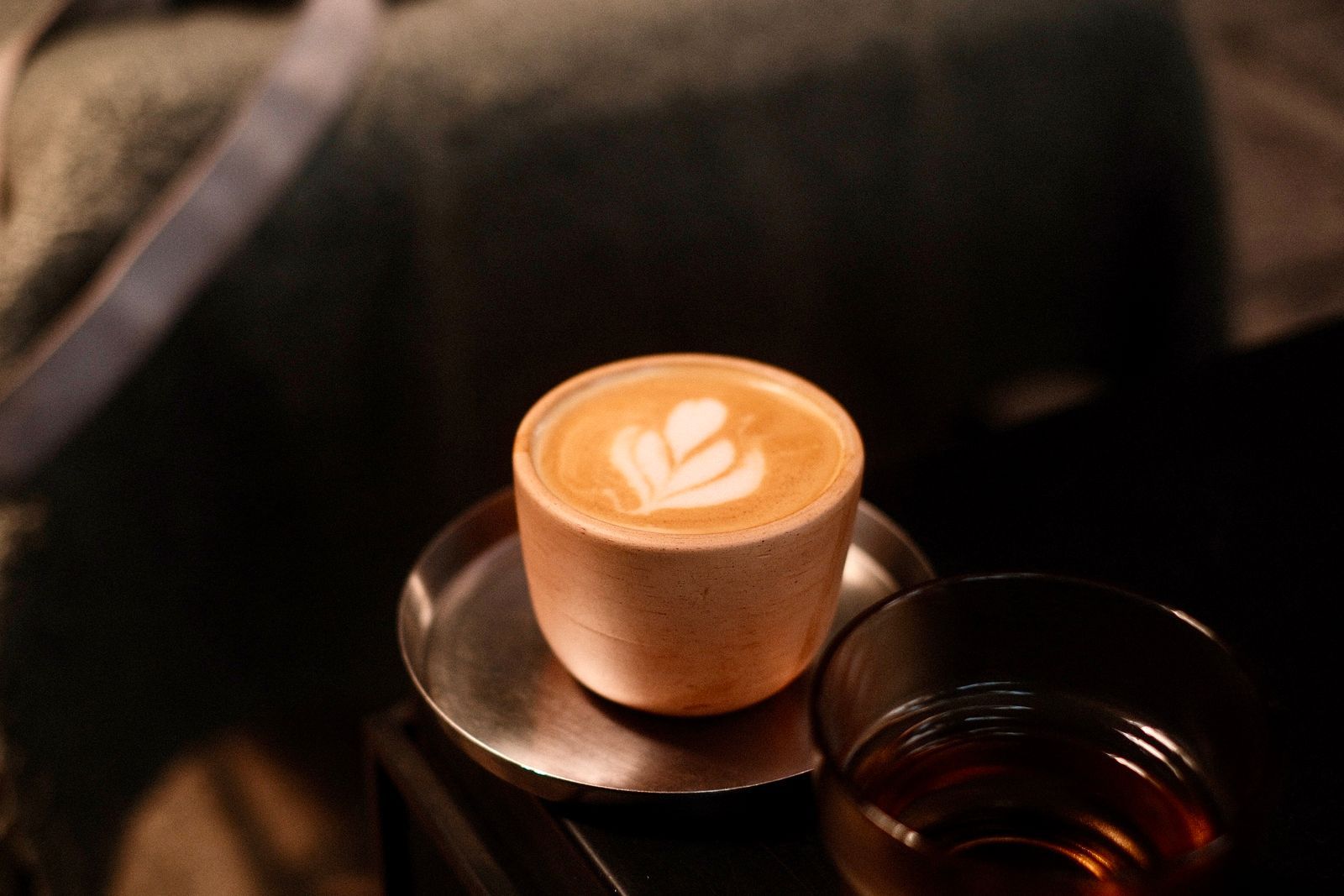 Latte art in a cup inside a softly lit café